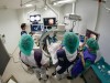 Undersøkelsesrom 113 er fullt av medisinsk teknologi.  12 ulike dataskjermer, tre leger, en ingeniør, en cytodiagnostiker og fire sykepleiere og en pasient må til under forsøkene med det nye bronkoskopet og navigasjonssystemet. Undersøkelsen ledes av lungelege Tor Amundsen, mens lege Hanne Sorger står "ved spakene". Foto: Thor Nielsen.