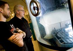 – I denne maskinen lager jeg nå små biter for nanolab’en på NTNU, sier finmekaniker Øystein Hagemo. Til høyre: Harald Snekvik, avdelingsleder ved Finmekanisk verksted, NTNU.