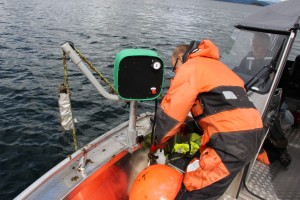 Jan Davidsen raises the aerosol can shaped listening station from Snillfjord as Lars Rømming pilots the boat. Photo: Nancy Bazilchuk