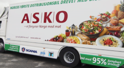 Hvit overbygd lastebil med logo fra ASKO og bilde av matvarer på karrosseriet.