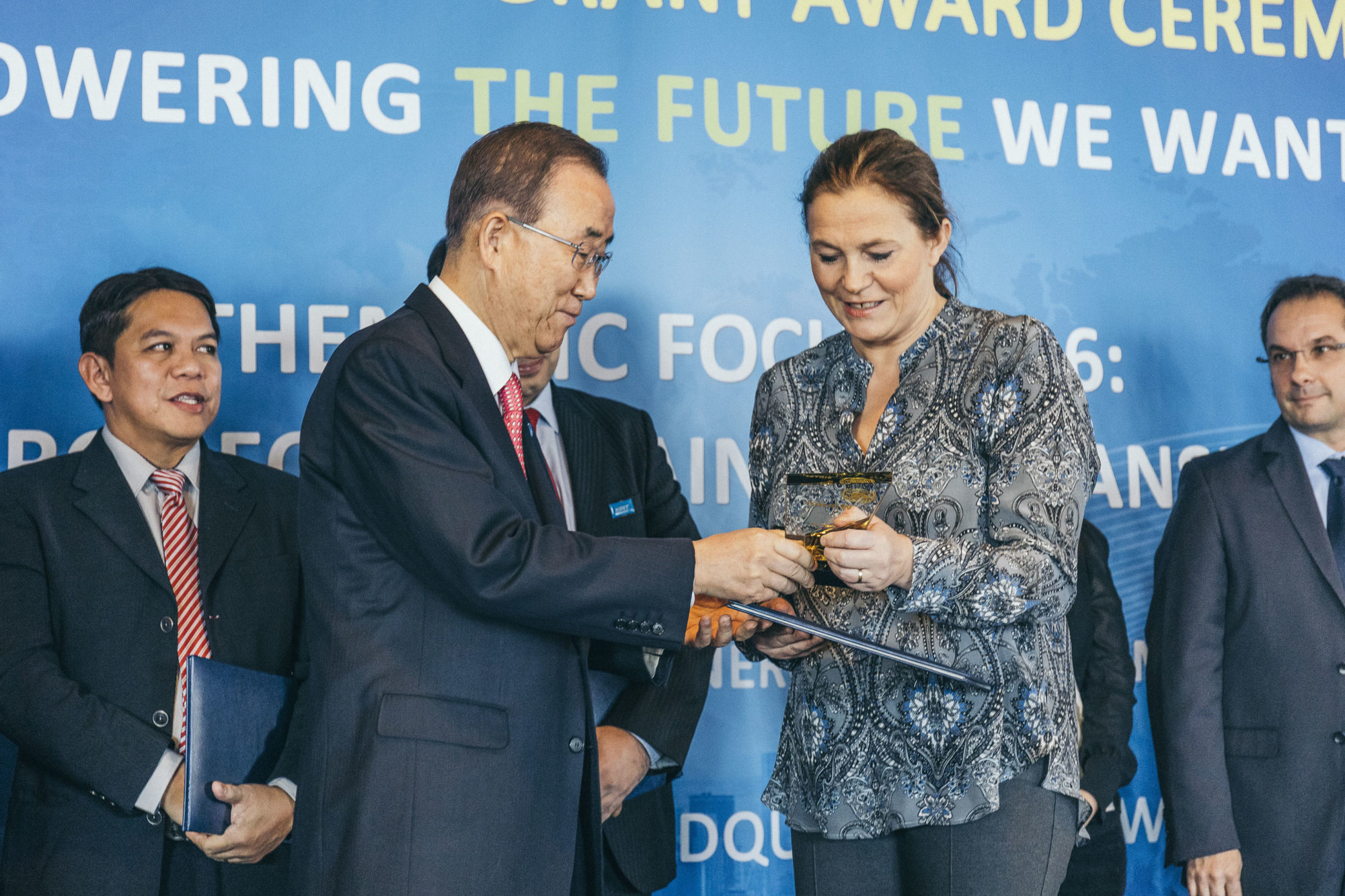 FNs generalsekretær Ban Ki-moon i samtale med SINTEF-sjef Alexandra Bech Gjørv i FN-bygningen i New York, foran himmelblå vegg, dekorert med innskriften "Powering the future we want"