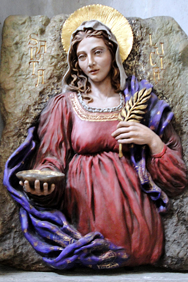 Denne fremstillingen av helgenen Lucia befinner seg i kirken som huser hennes relikvier. I hendene holder hun et fat med sine øyne og en palmegren. Foto: Audun Dybdahl