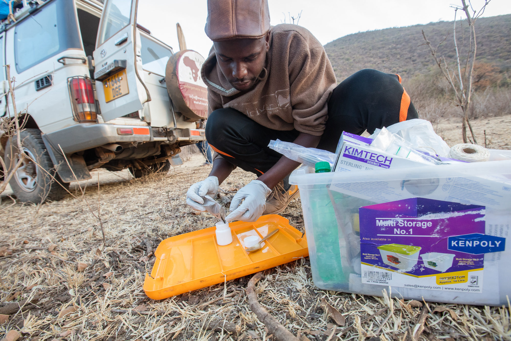Franco Mbise samler jordprøver for å sjekke DNA-spor fra rovdyr. Foto: Per Harald Olsen/NTNU