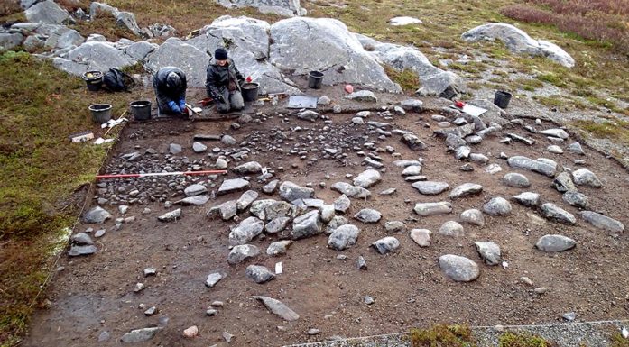 Dette bildet er fra utgravinga av en gjenbrukt teltplass datert til rundt 8300 f. Kr. fra Mohalsen på Vega i Nordland. Arkeolog Silje Fretheim sitter til høyre. FOTO: HEIN B. BJERCK