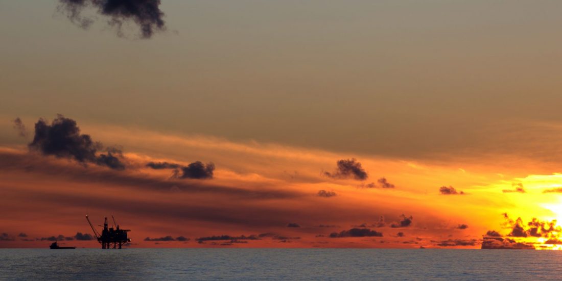 Solnedgang over Nordsjøen, der oljeplattform ses i det fjerne