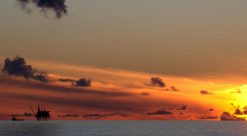 Solnedgang over Nordsjøen, der oljeplattform ses i det fjerne