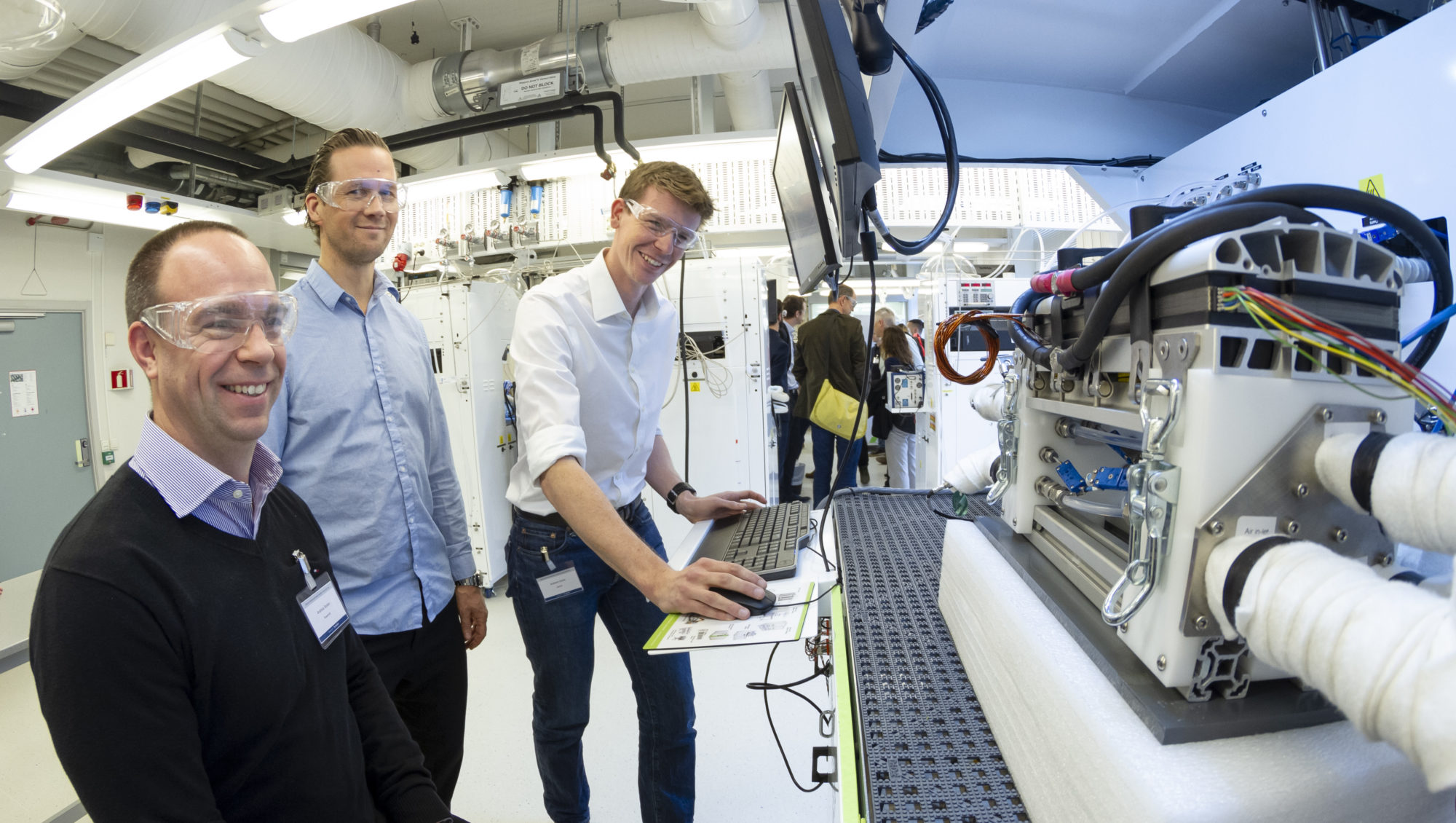 Forsker Graham Smith (til høyre) ved SINTEF demonstrer det nye hydrogenlaboratoriet i Trondheim under innvielsen. Gjestene er her representert ved Andreas Bodén og Johan Burgren fra den svenske brenselcelleprodusenten PowerCell. Foto: Thor Nielsen