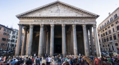 Det gamle betongbygget Pantheon i Roma fotografert mot søylene ved inngangspartiet. Store mengder turister skimtes i forgrunnen.