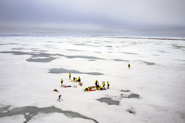 Bildet viser forskere i arbeid på is