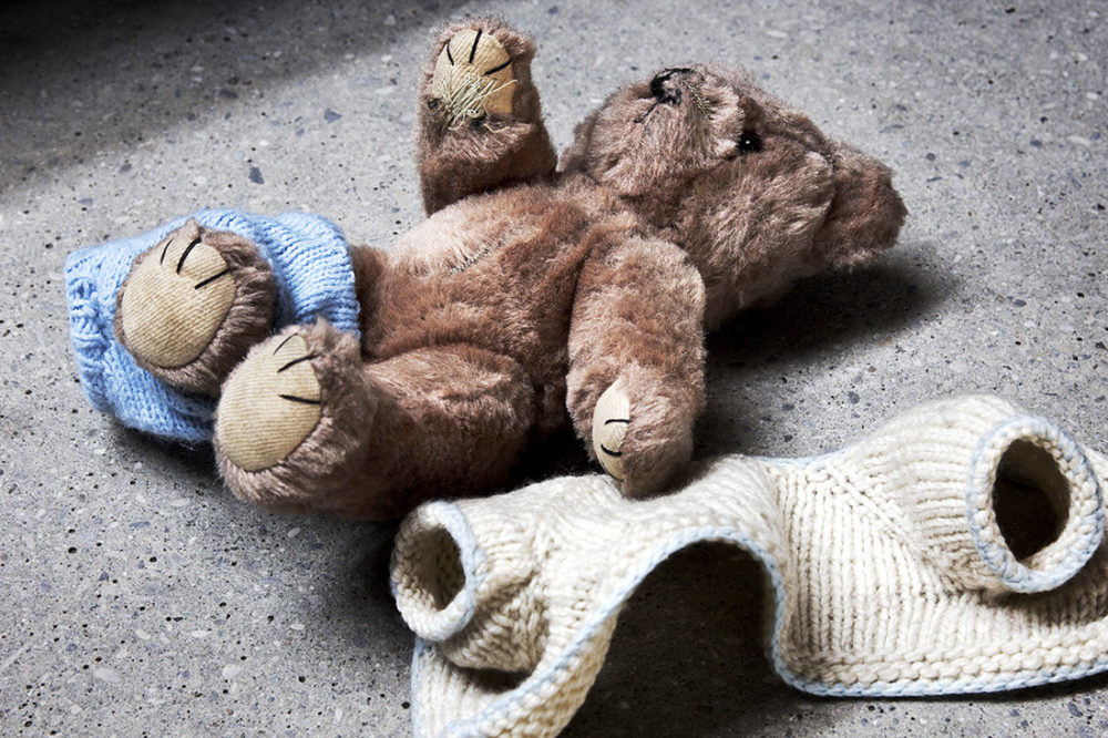 Teddybjørn ligger halvt avkledd på gulvet