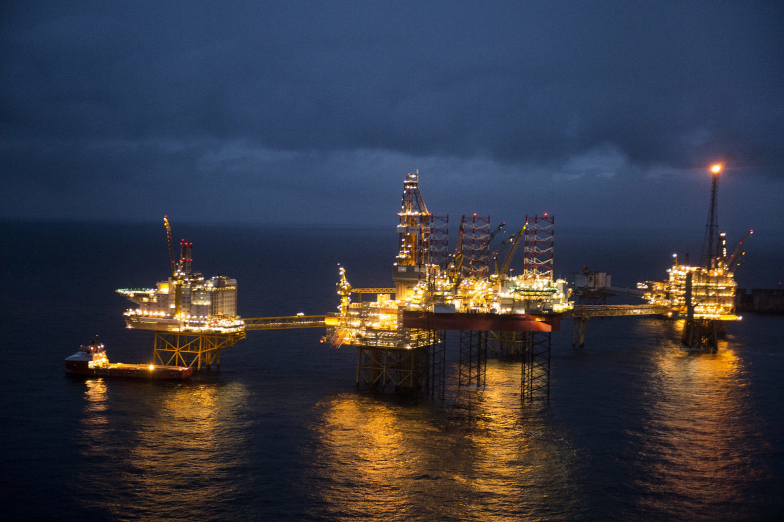 Nattbilde som viser tre opplyste oljeplattformer