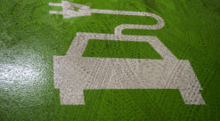 Stilisert bilde av elbile, malt med hvit farge på grønn asfalt