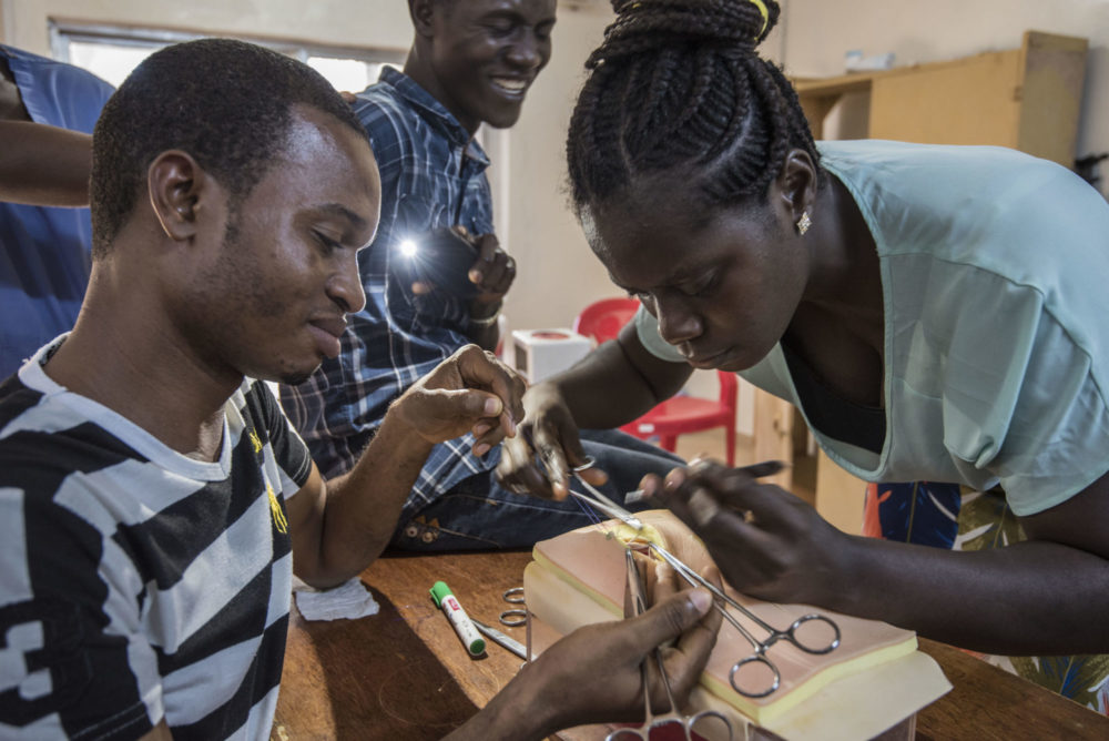 Bildet viser studenter i Sierra Leone som øver å operere på en modell.