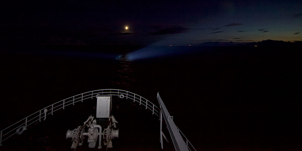 Bildet viser et forskningsfartøy i mørket, skjønt månen vises.