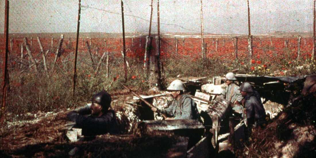 Fargebilde i rødbrune toner av soldater i skyttergrav under første verdenskrig.