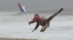 Kaos. Bildet viser en mann som mister fotfestet i vinden.