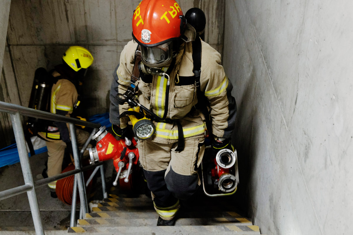 Brannkonstabler bærer tungt utstyr opp trapp