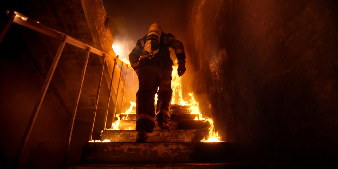 Brannkonstabel løper opp brennende trapp