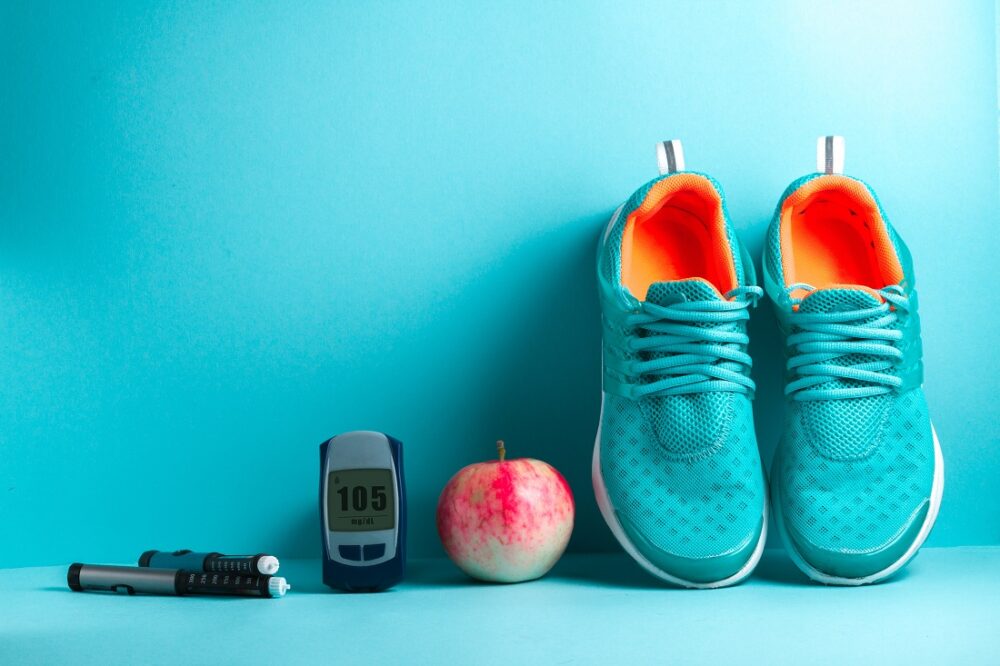 Diabetes. Bildet viser joggesko, eple og diabetesutstyr.