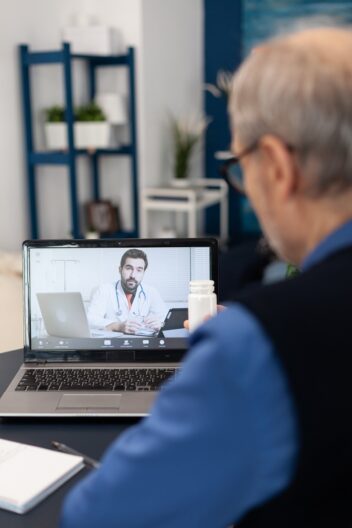 Helsevesenet. Bildet viser mann som snakker med legen på skjermen.