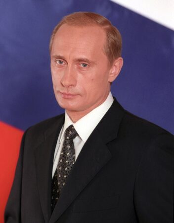 Bildet viser Vladimir Putin foran et russisk flagg.