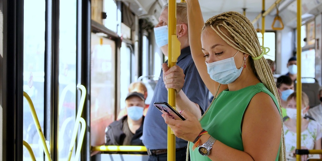 Vaner. Bildet viser folk med maske på en buss.