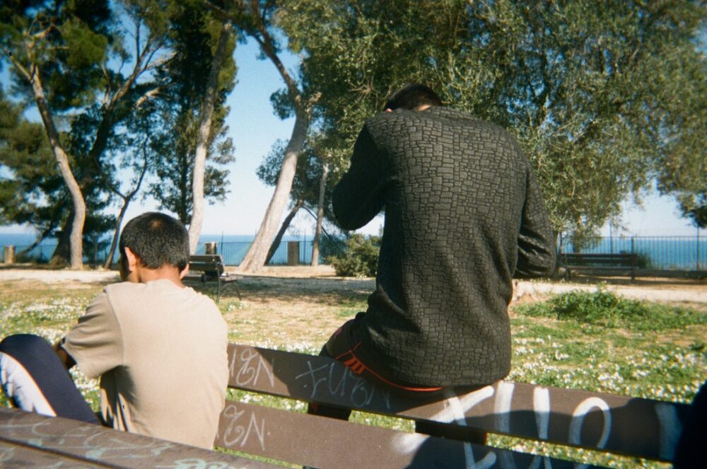 Moria. Bildet viser to ungdommer på en benk.
