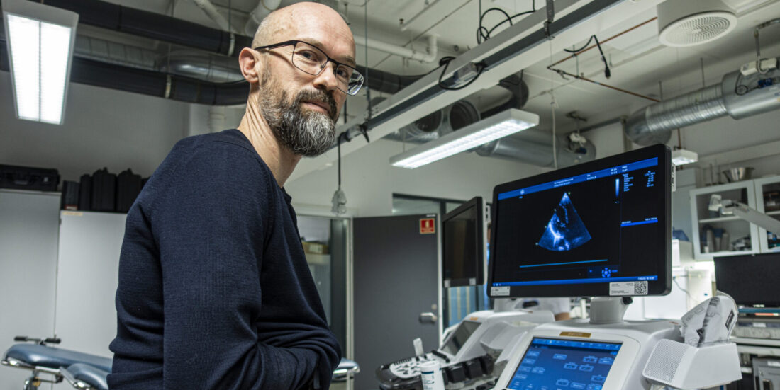 Mannlig forsker viser et ultralydbilde av eget hjerte
