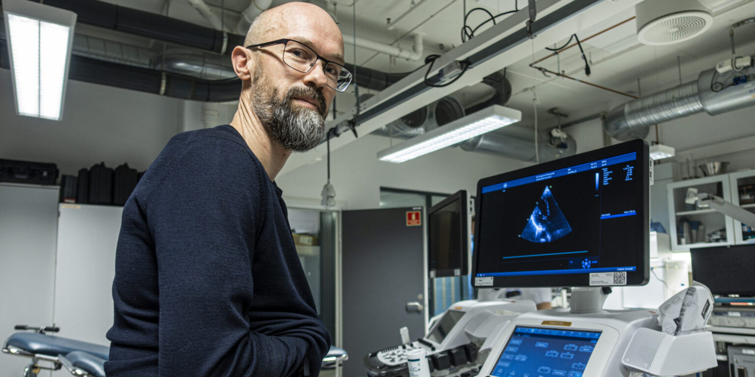 Mannlig forsker viser et ultralydbilde av eget hjerte
