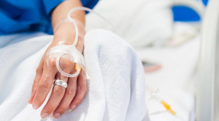 Sepsis. Bildet viser en hånd med drypp i en seng.