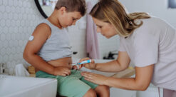 Kvinne setter sprøyte med insulin i magen på liten gutt