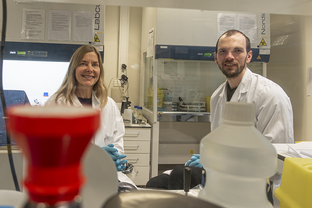 Kvinne og mann i hvite frakker på laboratorium