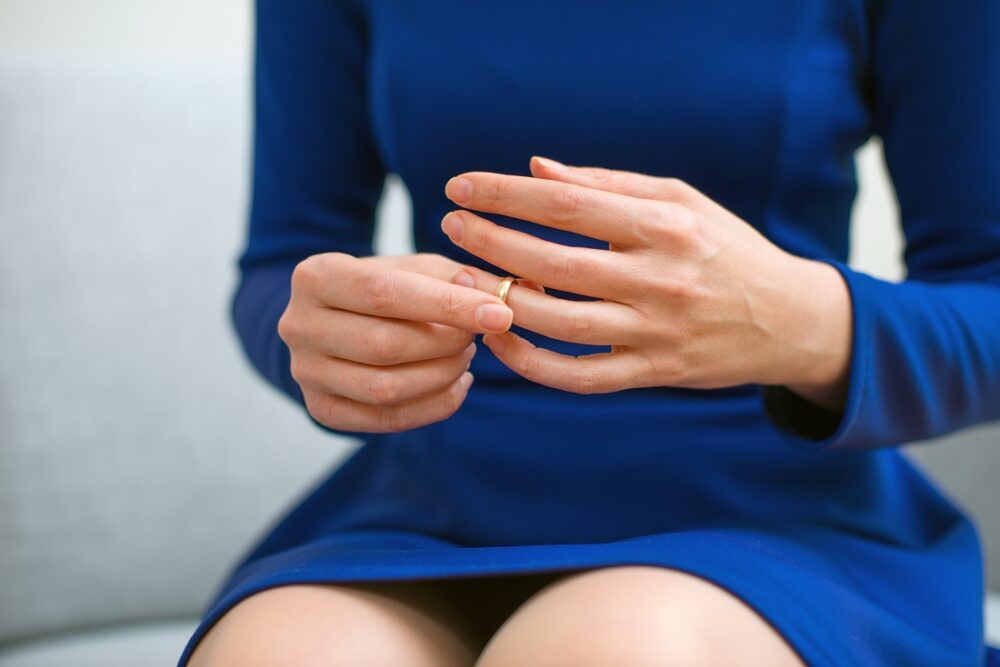 Sjalusi. Bildet viser en kvinne som tar av seg en ring.
