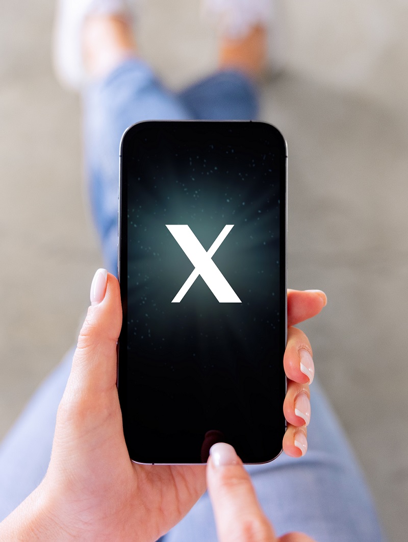 Sosiale medier. Bildet viser en jente med en mobiltelefon med en stor X.