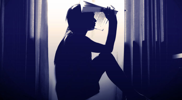 Bilde som viser sittende ung kvinne i silhuett mot vindu. Til artikkel om studielån og karakterer