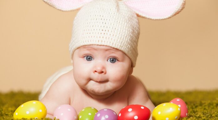 Påskequiz. Bildet viser en baby med harehatt og flere egg foran.