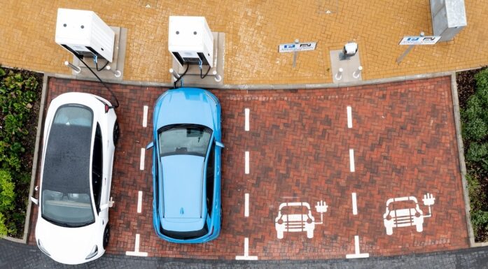 Elbiler. Bildet viser to biler på en parkeringsplass, fotografert ovenfra.