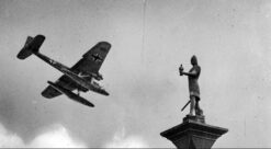 Fotomontasje. Tyskernes ankomst til Trondheim Holocaust: 9.april 1940. Et tysk fly kommer inn over Torvet, flyr over Vår Frue kirke og Olav Tryggvason-statuen. Flyet er en Heinkel HE-115.