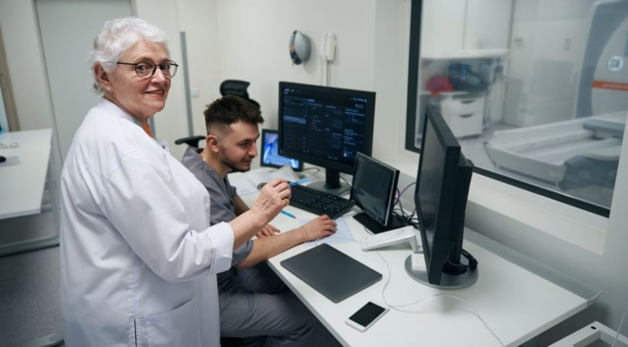 Eldre kvinne står i jobb på et laboratorium.