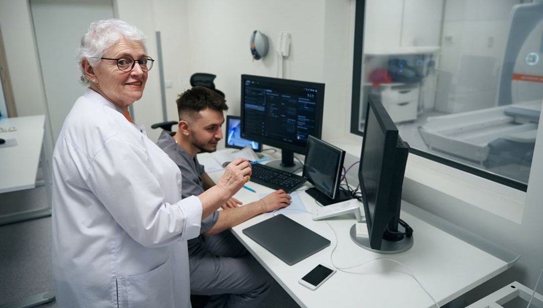 Eldre kvinne står i jobb på et laboratorium.