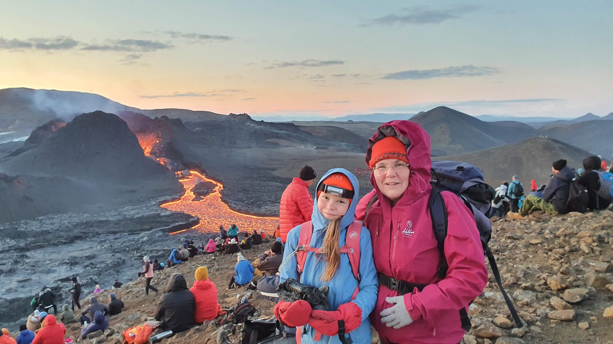 Bildet viser en aktiv vulkan med glødende lava og mange turister som ser på.
Bildet illustrerer en artikkel om jordvoller som beskytter mot lava.