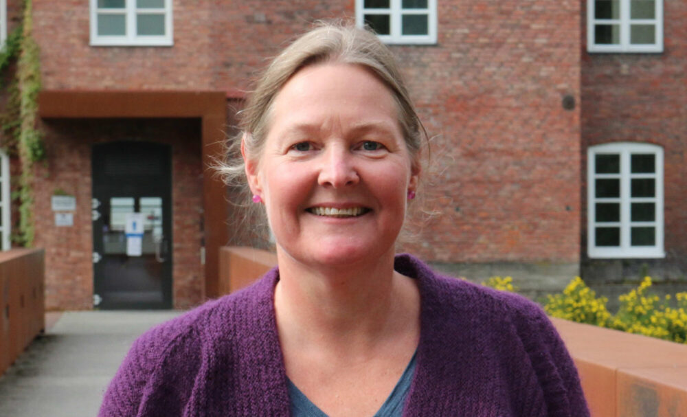 Kvinne foran murbygg. Til artikkel om prosjekt om eldre og syke som vil dø hjemme