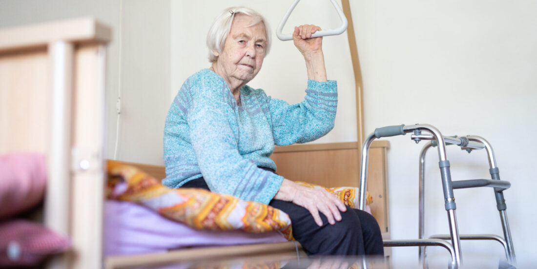 Vold mot eldre: Bildet viser en eldre kvinne som sitter på en sykeseng.