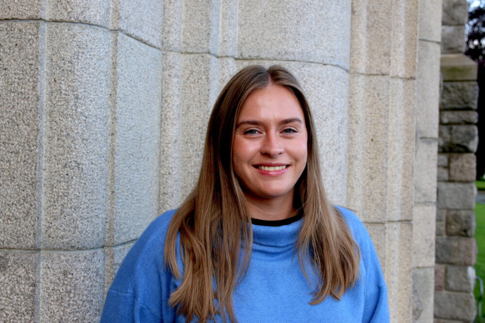 Foto viser forsker Julianne Lundanes mot en grå vegg.