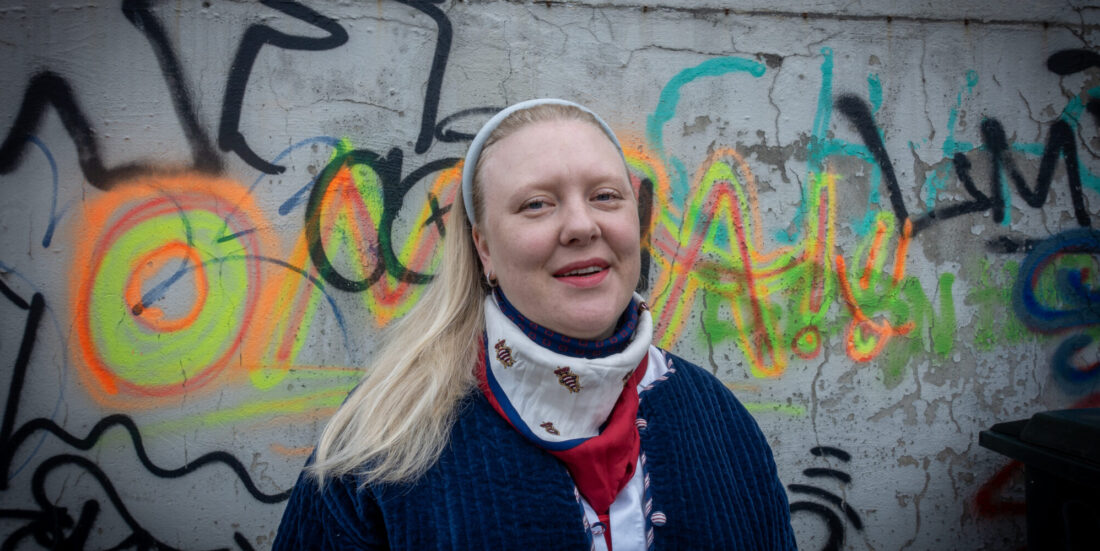 Portrett kvinne foran vegg med grafitti. Bilde til sak om utdanning i geografi.