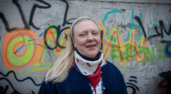 Portrett kvinne foran vegg med grafitti. Bilde til sak om utdanning i geografi.