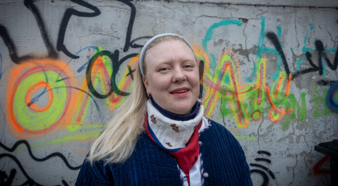 Portrett kvinne foran vegg med grafitti. Bilde til sak om utdanning i geografi.