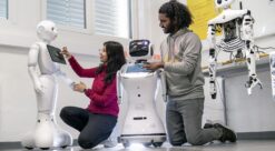En kvinne og en mann jobber med sosiale roboter i et laboratorium. Foto.