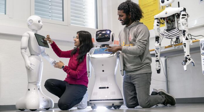 En kvinne og en mann jobber med sosiale roboter i et laboratorium. Foto.