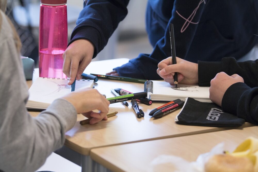 Læringspotensial. BIldet viser hendene til en gruppe elever.